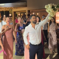 A man catches the brides bouquet at a wedding