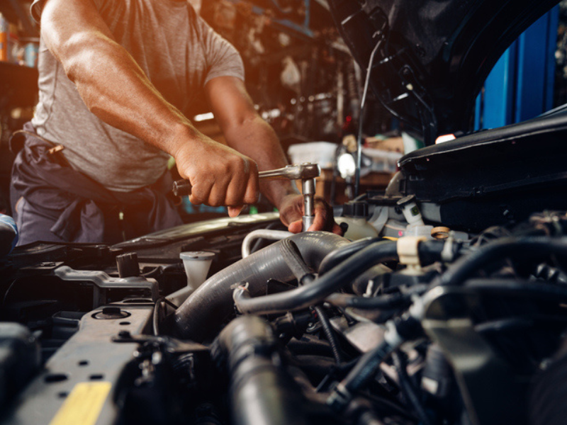 An auto mechanic conducting repairs and maintenance on a vehicle