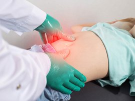 Doctor checking young girl with stomach pains