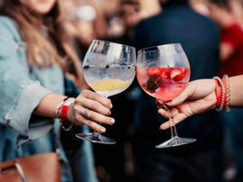 Two women toasting drinks during a music festival