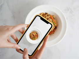 Woman takes picture of food using phone